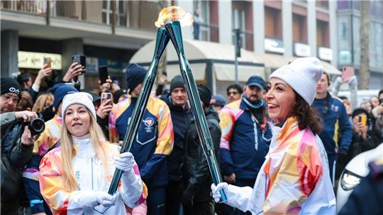 Olympische Winterspiele: Athletinnen beim Fackellauf mit der Flamme in Cortina D’ampezzo.
