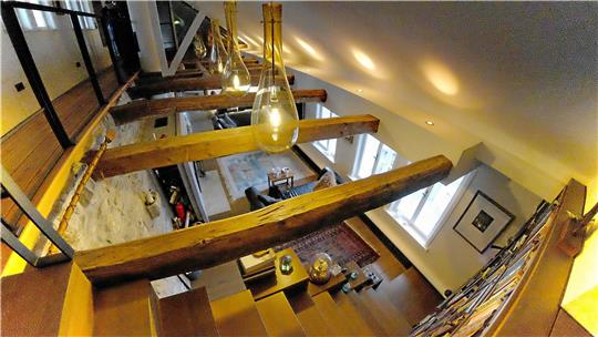 Optisch versteckte Treppen oder ein hydraulischer Fahrstuhl führen bis ganz nach oben: Aus dem Konglomerat an kleinen Mietwohnungen wurde ein behagliches Heim zum Wohlfühlen, mit immer wieder spannendem Lichtspiel. Die Lampen stammen aus der Glasbläserei in Derenburg. Fotos: Zietz (3)/Kempfer (2)