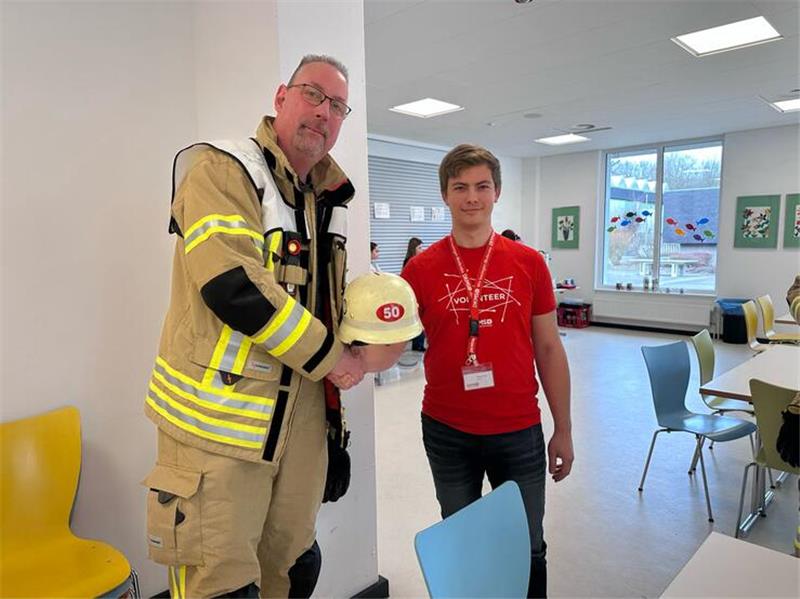 Hausarzt an Leukämie erkrankt: 300 Menschen lassen sich typisieren Ortsbrandmeister Martin Müller überreicht den Feuerwehrhelm mit den gesammelten Spenden an DKMS-Volunteer Philipp Groß.