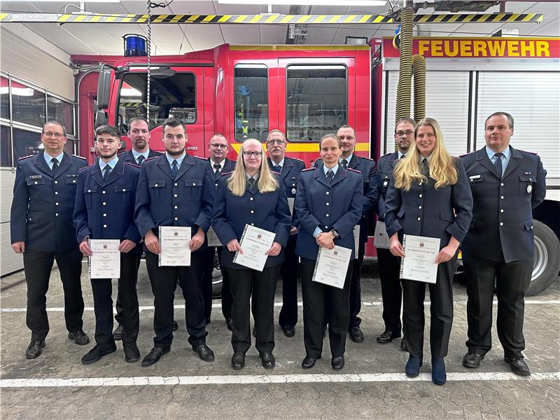 Ortsbrandmeister Thomas Hippler (r.) und Stadtbrandmeister Markus Finck (l.) mit den Beförderten (v.l.): Chris Jacobs, Peter Platzdasch, Kiel Thiel, Jens Volmer, Maja Müller, Jens Müller, Andrea Wellner, Peter Deike, Carsten Müller, Mette Daudert.