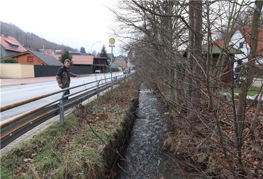 Ortsbürgermeister Burkhard Pahl an der Haltestelle kurz hinter der Töllebach-Brücke. Der Flusslauf wird von hier aus am teilweise abgängigen Ufer einige Hundert Meter in Richtung Ortsmitte befestigt, sodass die Straße nicht irgendwann absackt. Foto: Neddermeier