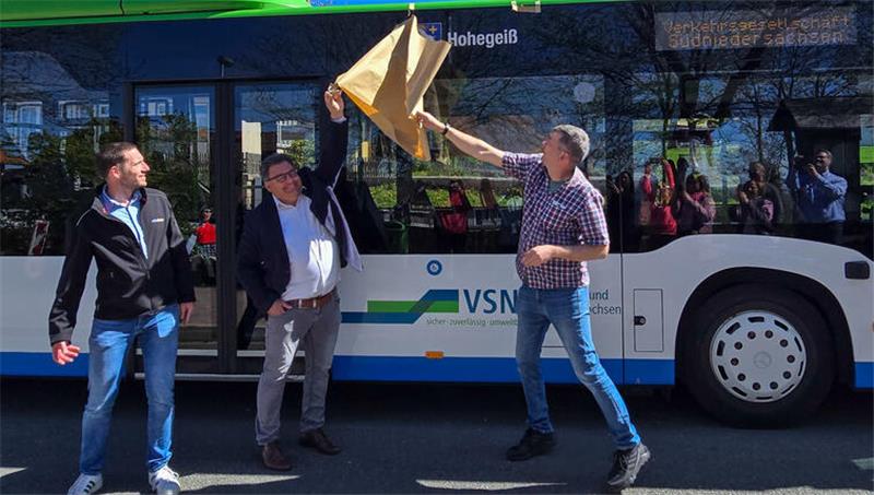 Das Foto zeigt einen Mann, der eine Decke von einem Bus zieht.