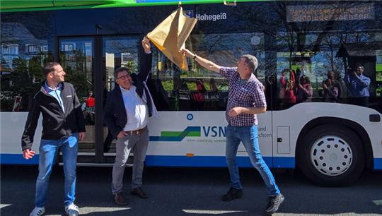 Das Foto zeigt einen Mann, der eine Decke von einem Bus zieht.