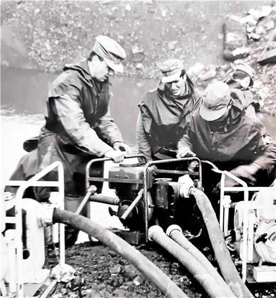 Ostern 1965, der Bach an der Mülldeponie ist über die Ufer getreten, sein Wasser muss umgelenkt werden, damit es nicht in die benachbarte Kläranlage läuft. Joachen Niebaum (l.) und seine THW-Kollegen sind vor Ort. Für ihn ist es der erste Einsatz als Helfer.  Foto: Privat