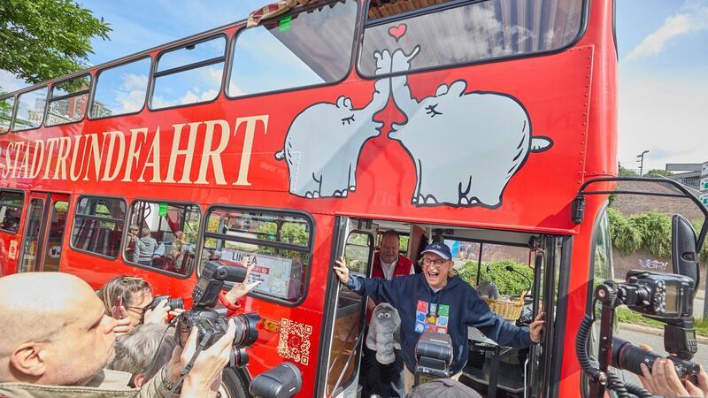 Otto Waalkes, Komiker, steht während der Einweihung eines Ottifanten-Doppeldeckerbusses an den Landungsbrücken in der Tür des Busses.