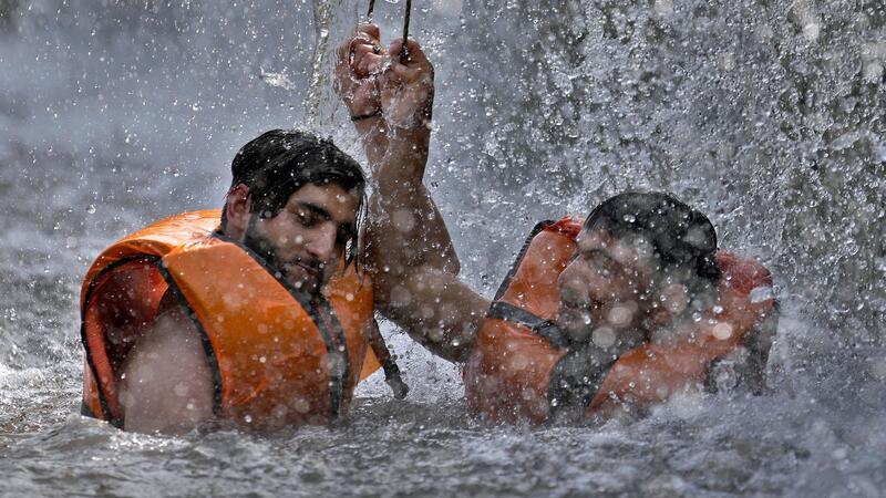 Pakistanische Männer kühlen sich in einem Bach ab, während die Temperaturen in Islamabad 39 Grad Celsius erreichen.