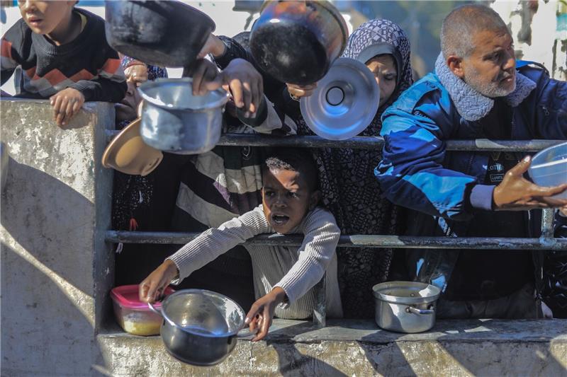Tel Aviv: UN-Gericht soll Gaza-Antrag Südafrikas ablehnen Palästinenser an einer von einer Wohltätigkeitsorganisation eingerichteten Lebensmittel-Spendenstelle.
