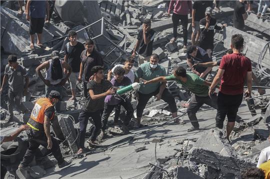 Palästinenser durchsuchen die Trümmer eines Gebäudes in Chan Yunis, das bei einem israelischen Luftangriff zerstört wurde.