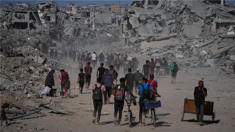 Palästinenser gehen an zerstörten Gebäuden vorbei, während sie in ihre Häuser im Zeitoun-Viertel von Gaza zurückkehren.