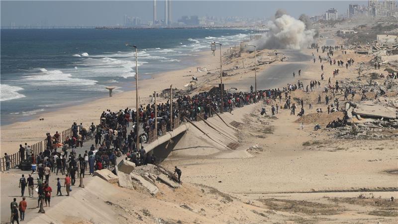 Palästinenser gehen entlang der Küstenstraße in der Nähe von Wadi Gaza im zentralen Gazastreifen in Richtung des nördlichen Gazastreifens.