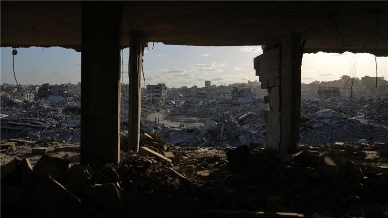 Palästinenser gehen zwischen den Trümmern der Stadt Gaza.