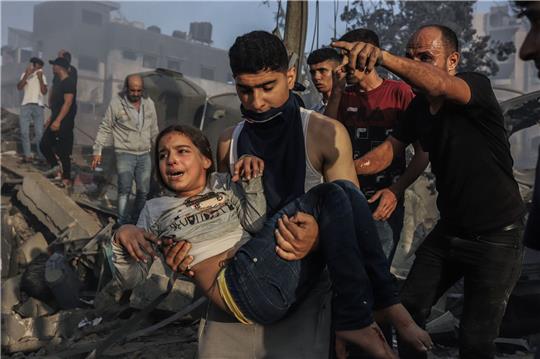 Palästinenser retten ein junges Mädchen aus den Trümmern eines zerstörten Gebäudes nach einem israelischen Luftangriff.