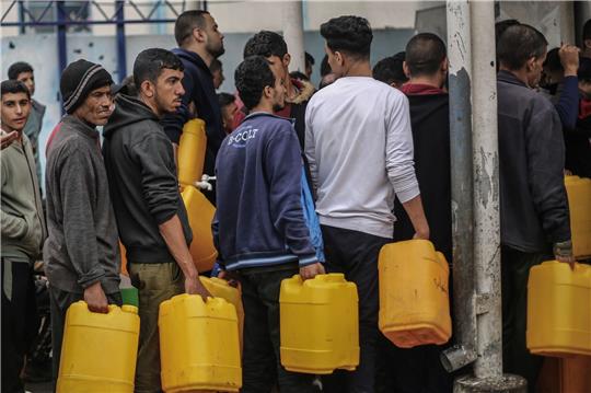 Palästinenser stehen Schlange, um sauberes Wasser aus einer Wasserstation zu erhalten. Die humanitäre Lage in Gaza ist katastrophal.
