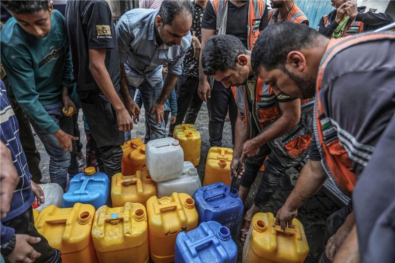 UN: Zwei Wasserversorger im Gazastreifen stellen Arbeit ein Palästinenser stehen in Rafah Schlange, um an Wasser zu gelangen.