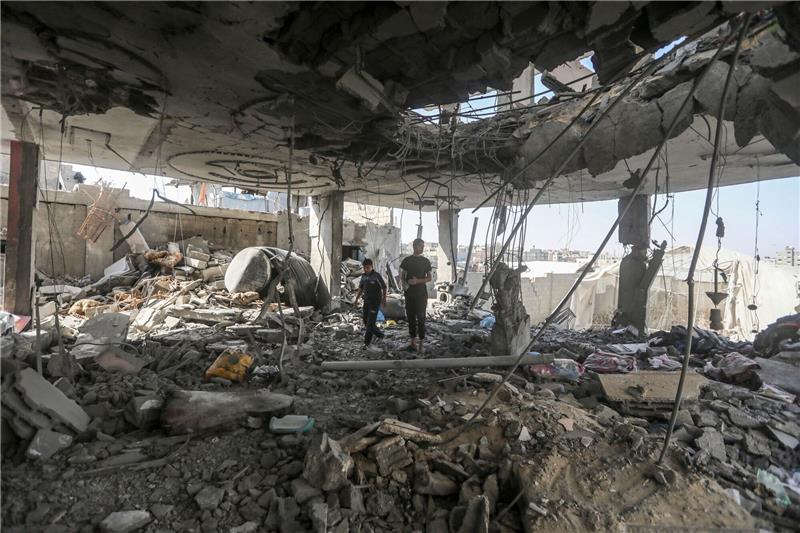 Berichte: Hamas für Verhandlungen über Waffenruhe in Kairo Palästinenser stehen in den Trümmern eines Hauses nach einem israelischen Luftangriff, bei dem mehrere Menschen getötet wurden.