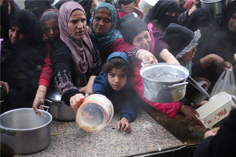 UN-Organisationen: Kinder verhungern im Gazastreifen Palästinenser stehen während der israelischen Luft- und Bodenoffensive für die kostenlose Verteilung von Lebensmitteln an.