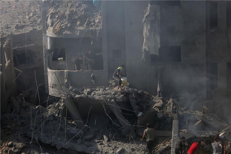 Gaza: Tausende wollen ausreisen - Kliniken kaum arbeitsfähig Palästinenser suchen in den Trümmern eines zerstörten Gebäudes in Bureij nach Überlebenden.