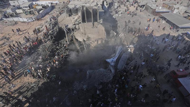 Palästinenser versammeln sich in Gaza und begutachten die Trümmer eines Gebäudes, das bei einem israelischen Luftangriff zerstört wurde.