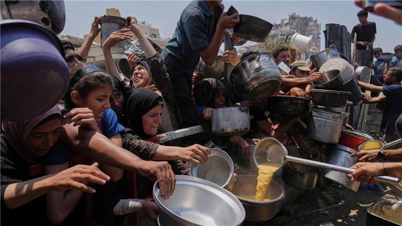 Palästinenser warten an einer Ausgabestelle für gespendete Lebensmittel im Gazastreifen. (Archivbild)