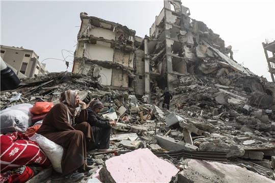 Palästinenserinnen sitzen auf Trümmern im Flüchtlingslager Nuseirat im Gazastreifen nach dem Abzug der israelischen Streitkräfte (IDF).