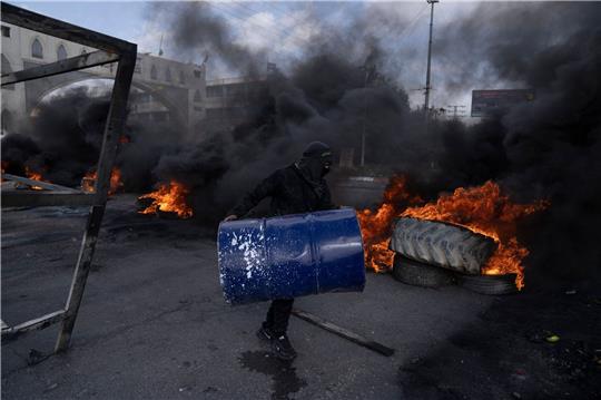 Palästinensische Demonstranten blockieren nach dem Einsatz des israelischen Armee in Jericho eine Straße mit brennenden Reifen.