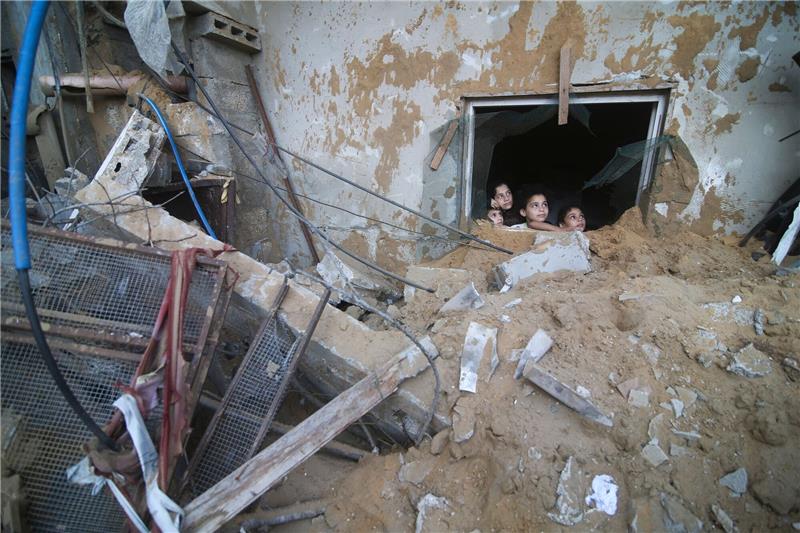 Bodenoffensive in Gaza erwartet - Nahost-Flächenbrand droht Palästinensische Kinder schauen in Rafah im Süden des Gazastreifens aus einem Fenster, das bei israelischen Luftangriffen zerstört wurde.