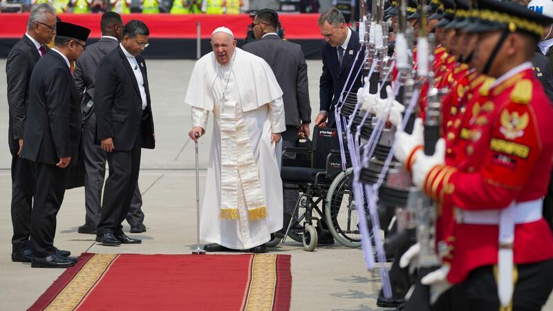 Papst Franziskus ist in Indonesien und steht am internationalen Flughafen von Jakarta neben der Ehrengarde.
