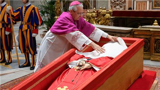 Papst Franziskus wird ein Leinentuch über das Gesicht gelegt.