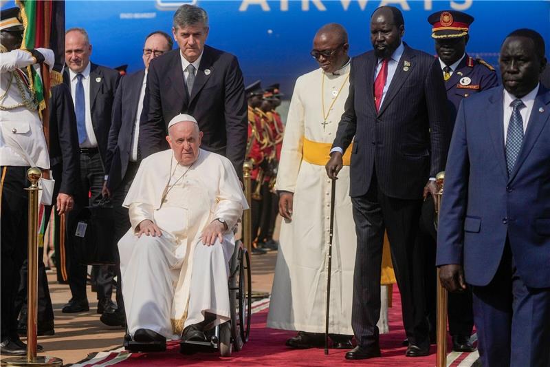 Südsudan hofft auf Friedensmission des Papstes Papst Franziskus wird vom südsudanesischen Präsidenten Salva Kiir (3.v.r) auf dem Flughafen von Juba empfangen.