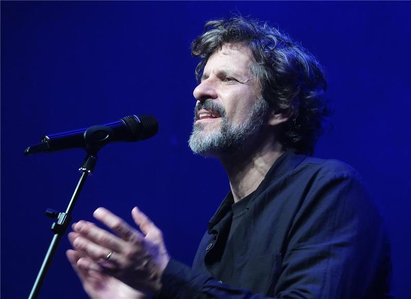 Ein Mann singt ins Mikro.