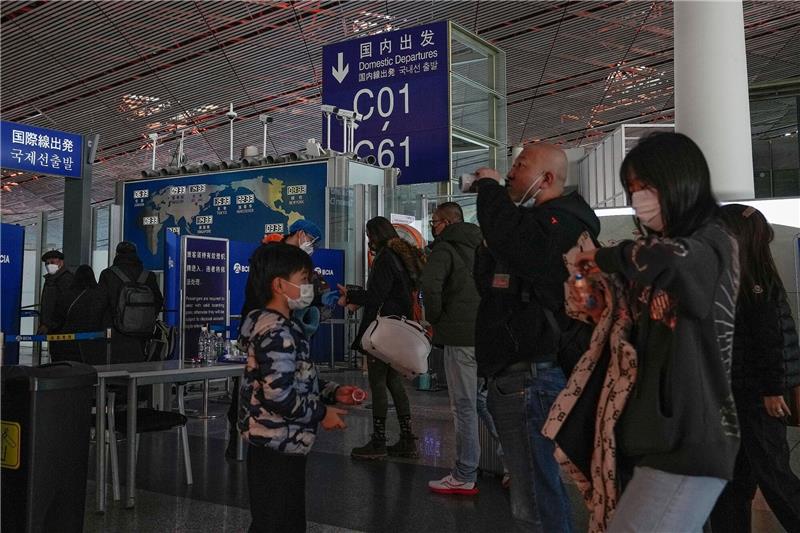 Covid-Test bei Einreise aus China: Wie geht Deutschland vor? Passagiere mit Mund-Nasen-Schutz stehen am Flughafen Peking an der Sicherheitskontrolle vor einem internationalen Abfluggate an.