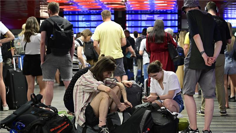 Passagiere sitzen in der Halle des Prager Hauptbahnhofs während eines Stromausfalls. 