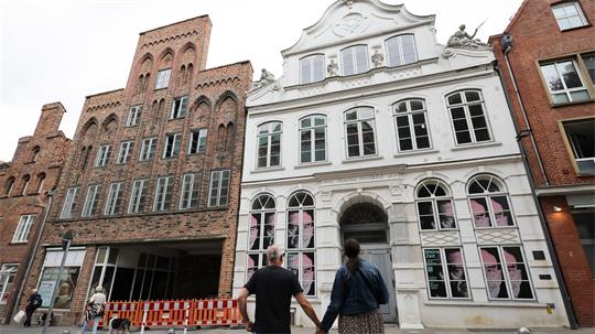 Passanten betrachten das geschlossene Buddenbrookhaus in der Lübecker Altstadt.
