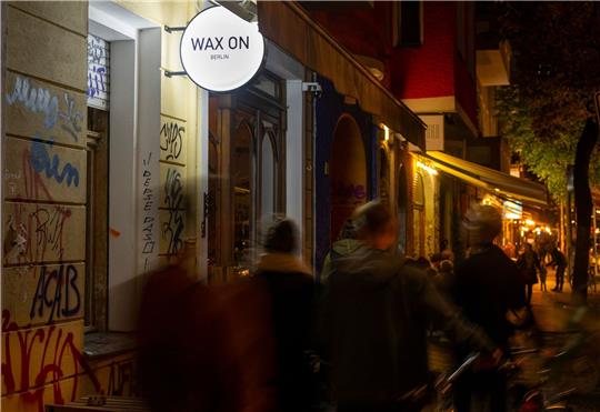 Passanten gehen am Abend vorbei an der Neuköllner Bar «Wax On».