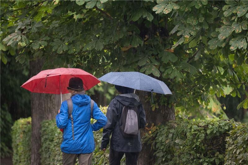 Abschied vom Sommer mit durchwachsenem Wetter Passanten mit Regenschirmen in Moritzburg in Sachsen.