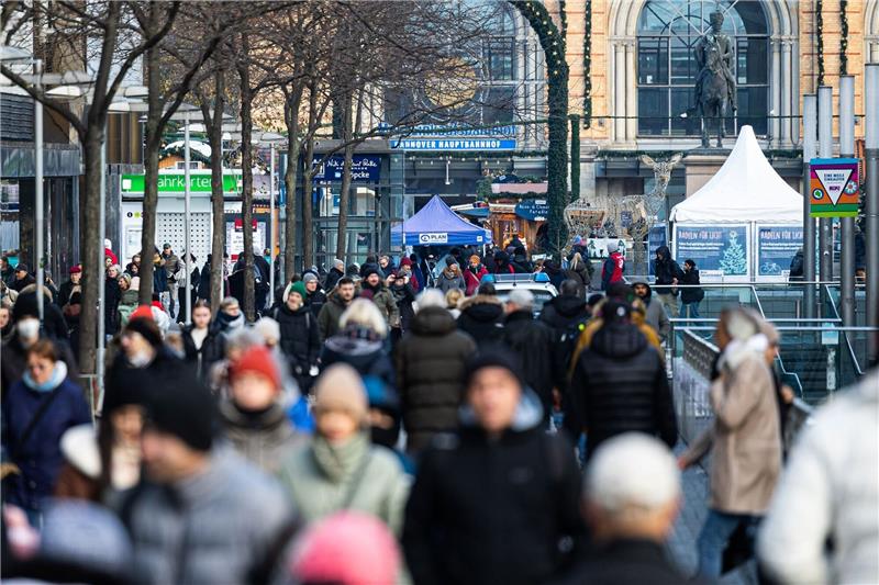 Passantinnen und Passanten gehen in der Fußgängerzone in der Innenstadt.
