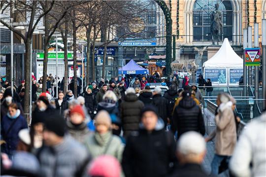 Passantinnen und Passanten gehen in der Fußgängerzone in der Innenstadt.