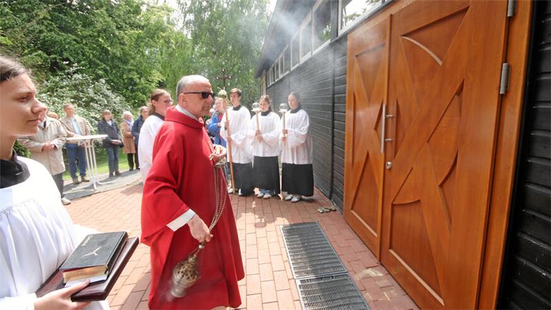 Pastor Ulrich Schmalstieg segnet die neue Eingangstür der katholischen Herz-Mariä-Kirche in Langelsheim.
