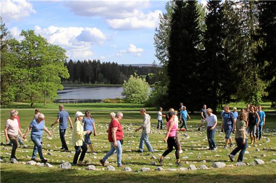 Patienten und Mitarbeiter des Rehazentrums Oberharz bauen aus Steinen ein Labyrinth (keinen Irrgarten) im Klinikgarten und sind die ersten, die hindurchgehen. Foto: Knoke