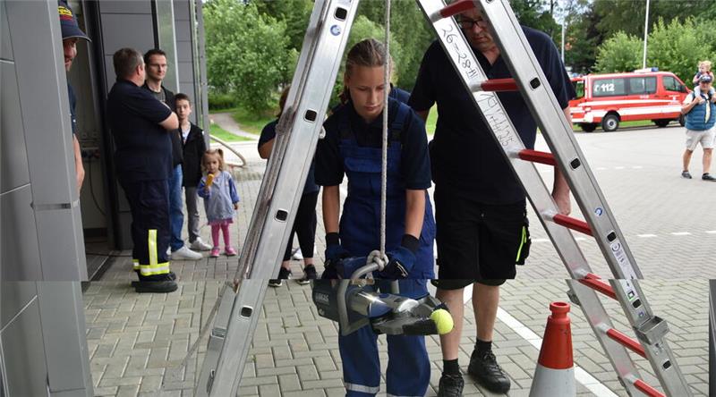 Paula aus Hohegeiß schafft es bei einem Feuerwehr-Spaßtag, den Tennisball von einem Warnkegel auf einen anderen zu transportieren.