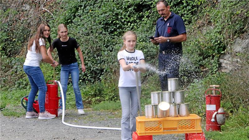 Per Kübelspritze gilt es bei der Waldrallye, mit dem Wasserstrahl in einer bestimmten Zeit Dosen umzuschießen.