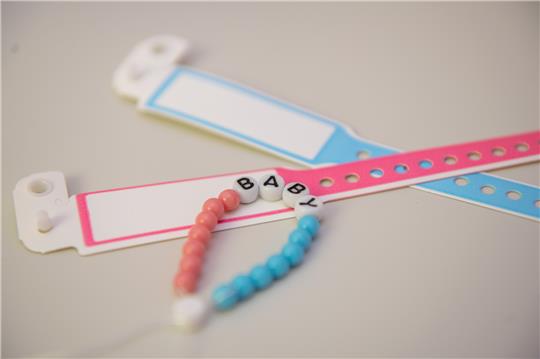 Perlenarmband sowie Neugeborenenarmbänder in blau und rosa. Foto: picture alliance/dpa | Stefan Puchner