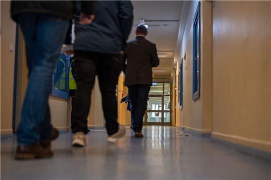 Personen gehen in einem Gang der Aufnahmeeinrichtung für Asylbegehrende.