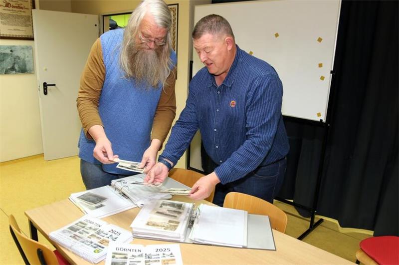 Peter Pförtner und Dirk Grätz sichten für den Dörnter Kalender 2025 zahllose Postkarten.
