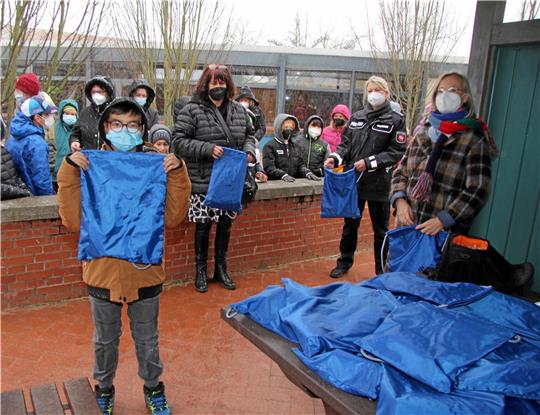Petra Franke, Stephani Gobernack und Miriam Albers (v.li.) verteilen insgesamt 40 Info-Taschen an die Schülerinnen und Schüler der Harly-Schule.  Foto: Hohaus