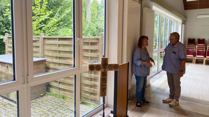 Bündheimer Gemeinde spart Heizkosten und bekommt mehr Licht Pfarrer Dirk Westphal und Hausmeisterin Edelgard Enderich-Lampe vor der neuen großen Fensterfront im Saal des Gemeindehauses. Mittig wurden zwei der sechs Wandheizkörper installiert.