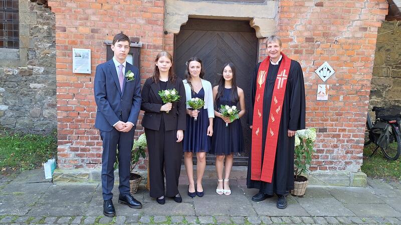 Vier jungen Menschen sind jetzt erwachsene Christen Pfarrer Frank Ahlgrim (r.) und die Konfirmanden Hendrik Klann (v.li.), Charlotte Neuss, Hanna Rössing und Sinja Schröder stellen sich zum Erinnerungsfoto auf.