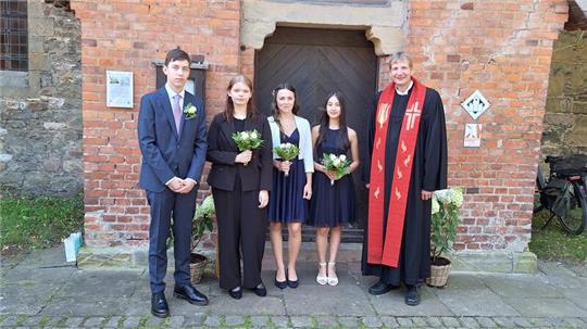 Pfarrer Frank Ahlgrim (r.) und die Konfirmanden Hendrik Klann (v.li.), Charlotte Neuss, Hanna Rössing und Sinja Schröder stellen sich zum Erinnerungsfoto auf.