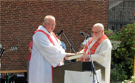 Pfarrer Thomas Mogge hält ein Versprechen mit einem Handauflegen auf die Bibel und das Handauflegen mit einem Glaubensbekenntnis bei Pater Paulus. Foto: Hohaus