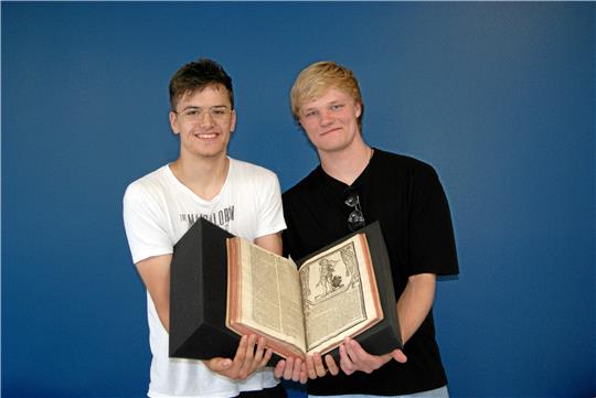 Phil Luca Krause und Tom Linde mit einem historischen Druck aus der Goslarer Marktkirchenbibliothek.  Fotos: Brummer